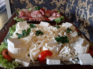 Masada çeşitli peynirlerle servis edilen peynir tabağı.