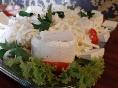 Masada çeşitli peynirlerle servis edilen peynir tabağı.