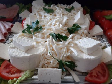 Masada çeşitli peynirlerle servis edilen peynir tabağı.