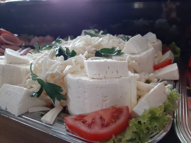 Masada çeşitli peynirlerle servis edilen peynir tabağı.