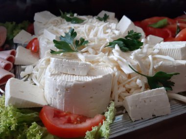 Masada çeşitli peynirlerle servis edilen peynir tabağı.