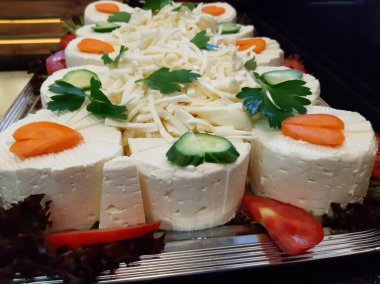 Masada çeşitli peynirlerle servis edilen peynir tabağı.