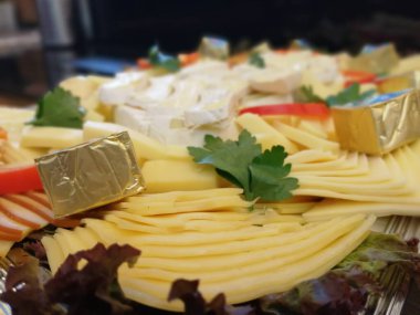 Masada çeşitli peynirlerle servis edilen peynir tabağı.