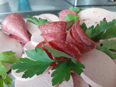 Servis tabağında dilimlenmiş salam çeşitleri