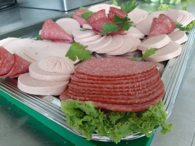 Servis tabağında dilimlenmiş salam çeşitleri