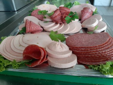 Servis tabağında dilimlenmiş salam çeşitleri