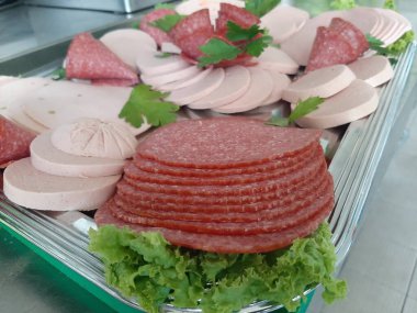 Servis tabağında dilimlenmiş salam çeşitleri