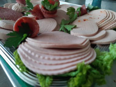 Servis tabağında dilimlenmiş salam çeşitleri