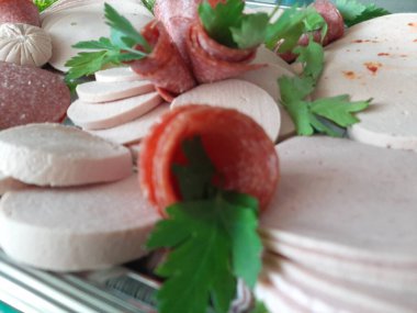 Servis tabağında dilimlenmiş salam çeşitleri