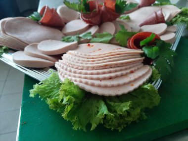 Servis tabağında dilimlenmiş salam çeşitleri