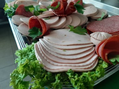 Servis tabağında dilimlenmiş salam çeşitleri