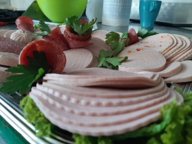 Servis tabağında dilimlenmiş salam çeşitleri