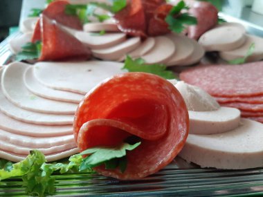 Servis tabağında dilimlenmiş salam çeşitleri