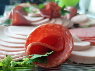 Servis tabağında dilimlenmiş salam çeşitleri