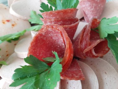 Servis tabağında dilimlenmiş salam çeşitleri