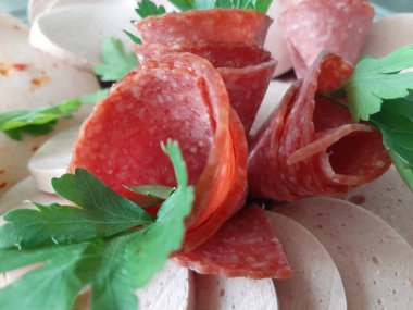 Servis tabağında dilimlenmiş salam çeşitleri