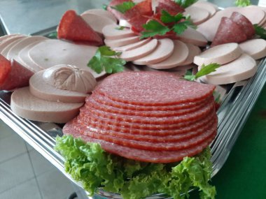 Servis tabağında dilimlenmiş salam çeşitleri