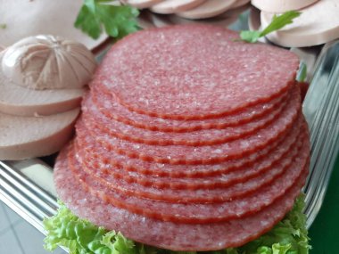 Servis tabağında dilimlenmiş salam çeşitleri