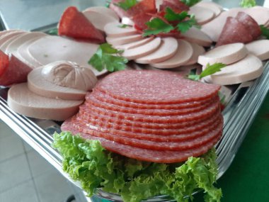 Servis tabağında dilimlenmiş salam çeşitleri