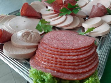 Servis tabağında dilimlenmiş salam çeşitleri