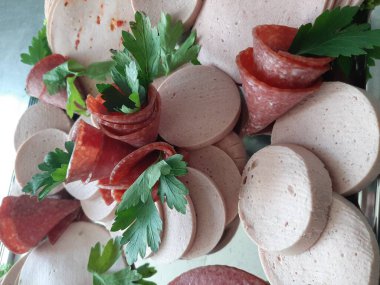 Servis tabağında dilimlenmiş salam çeşitleri