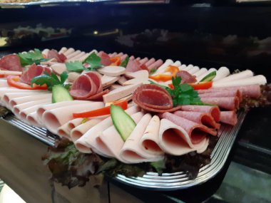 Servis tabağında dilimlenmiş salam çeşitleri