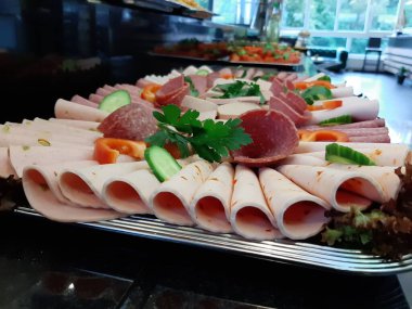 Servis tabağında dilimlenmiş salam çeşitleri