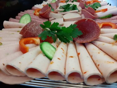 Servis tabağında dilimlenmiş salam çeşitleri