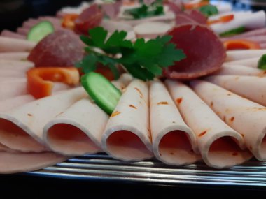 Servis tabağında dilimlenmiş salam çeşitleri