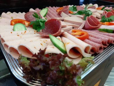 Servis tabağında dilimlenmiş salam çeşitleri