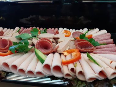 Servis tabağında dilimlenmiş salam çeşitleri