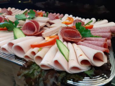 Servis tabağında dilimlenmiş salam çeşitleri