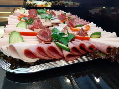 Servis tabağında dilimlenmiş salam çeşitleri