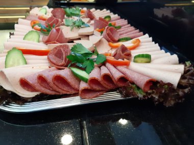 Servis tabağında dilimlenmiş salam çeşitleri