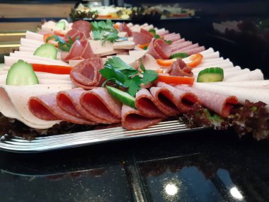 Servis tabağında dilimlenmiş salam çeşitleri