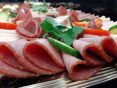 Servis tabağında dilimlenmiş salam çeşitleri