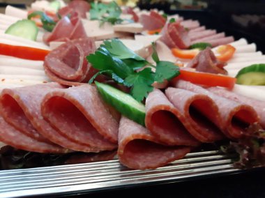 Servis tabağında dilimlenmiş salam çeşitleri