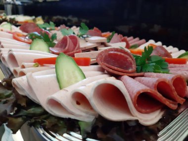 Servis tabağında dilimlenmiş salam çeşitleri