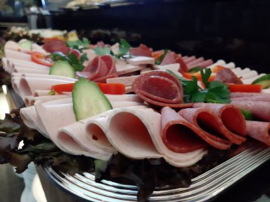 Servis tabağında dilimlenmiş salam çeşitleri