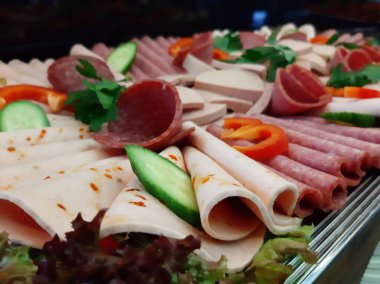 Servis tabağında dilimlenmiş salam çeşitleri