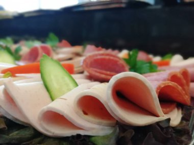 Servis tabağında dilimlenmiş salam çeşitleri