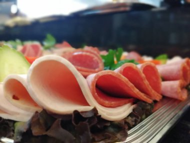 Servis tabağında dilimlenmiş salam çeşitleri