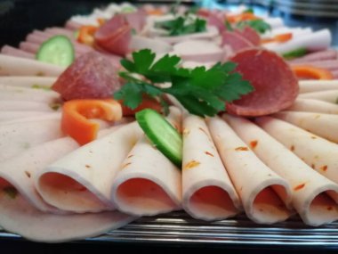 Servis tabağında dilimlenmiş salam çeşitleri