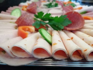 Servis tabağında dilimlenmiş salam çeşitleri