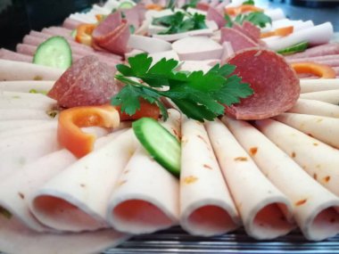 Servis tabağında dilimlenmiş salam çeşitleri