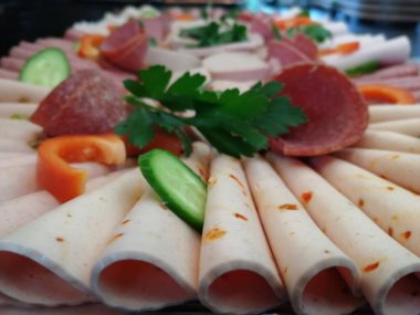 Servis tabağında dilimlenmiş salam çeşitleri