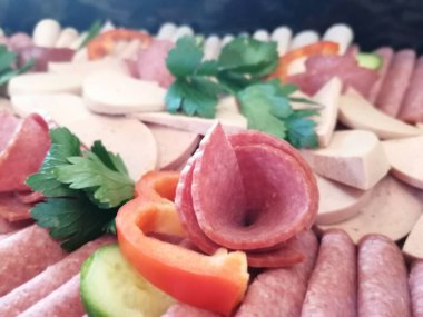 Servis tabağında dilimlenmiş salam çeşitleri