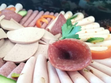 Servis tabağında dilimlenmiş salam çeşitleri