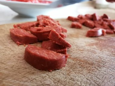 Servis masasında dilimlenmiş sosis.