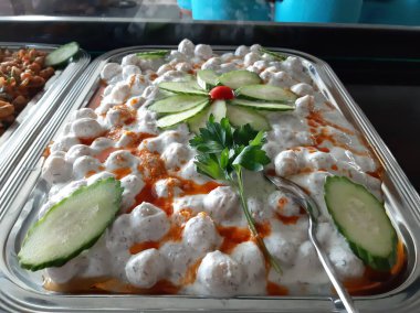 Servis tabağında lezzetli tereyağlı Türk mantısı.